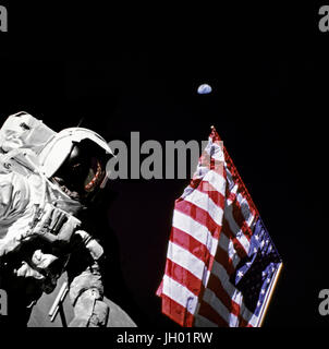 Geologe-Astronaut Harrison Schmitt, Pilot der Mondlandefähre von Apollo 17, ist neben der amerikanischen Flagge während Extravehicular Activity (EVA) von der Mission der NASA letzten Mondlandung der Apollo-Serie fotografiert. Das Foto wurde am Taurus-Littrow-Landeplatz. Der höchste Teil der Flagge scheint in Richtung unseres Planetenerde im fernen Hintergrund zeigen. Fotograf: NASA / Eugene Cernan Stockfoto