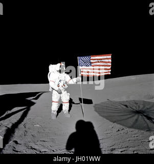 Astronaut Alan B. Shepard Jr., Kommandant der Apollo 14, steht in den frühen Momenten der ersten Extravehicular Activity (EVA-1) der Mission durch die US-Flagge auf der lunar Fra Mauro-Hochland. Schatten der Mondlandefähre "Antares", Astronaut, umgeben von Edgar D. Mitchell, Pilot der Mondlandefähre und aufrichtbar S-Band Antenne die Szene der dritten amerikanischen Flagge Pflanzung auf der Mondoberfläche durchgeführt werden. NASA-Foto Stockfoto