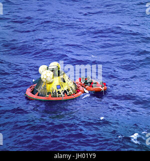 Die Apollo 11 Crew warten auf Abholung von einem Hubschrauber von der USS Hornet, erstklassige Erholung Schiff für die historische Mission der Apollo 11 Mondlandung. Der vierte Mann in der Rettungsinsel ist ein United States Navy underwater Demolition Team Schwimmer. Alle vier Männer tragen biologischen Isolation Kleidungsstücke (BIG). Apollo-11-Kommandokapsel "Columbia" mit Astronauten Neil A. Armstrong, Michael Collins und Edwin E. Aldrin Jr. wasserte am 11:49 (CDT), 24. Juli 1969, ca. 812 Seemeilen südwestlich von Hawaii und nur 12 Seemeilen von der USS Hornet. Stockfoto