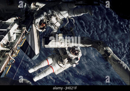 Astronauten-Linda M. Godwin (rote Streifen) und Daniel M. Tani, beide Spezialisten STS-108-Mission sind nahe dem Ende des Space Shuttle Endeavour remote Manipulator System (RMS) Roboterarms während der vier Stunden, 12 Minuten Sitzung Extravehicular Activity (EVA) abgebildet. Stockfoto