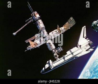 Diese Ansicht des Space Shuttle Atlantis noch angeschlossen an die russische Raumstation wurde am 4. Juli 1995 von Mir-19-Mannschaft fotografiert. Kosmonauten Anatoliy Y. Solovyev und Nikolai M. Budarin, Mir-19 Kommandant und Flugingenieur, abgedockt, vorübergehend das Sojus-Raumschiff aus dem Cluster von Mir Elementen zu einem kurzen Rundflug durchführen. Sie fotografierte während der STS-71-Crew mit Mir-18 drei Besatzungsmitglieder an Bord, nicht angedockte Atlantis für den Abschluss dieser Etappe der gemeinsamen Aktivitäten. Stockfoto