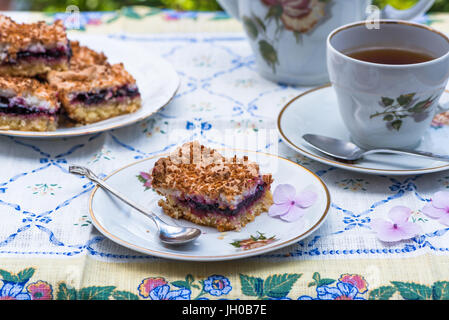 Johannisbeer Kokos Slice mit Tee auf einem Tisch im Garten Stockfoto