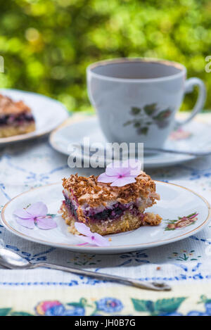 Johannisbeer Kokos Slice mit Tee auf einem Tisch im Garten Stockfoto