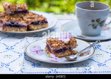 Johannisbeer Kokos Slice mit Tee auf einem Tisch im Garten Stockfoto