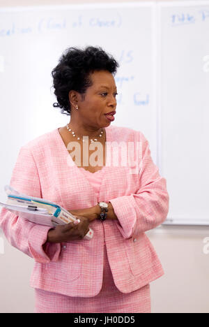 Ein afrikanischer amerikanischer Professor unterrichtet eine Klasse beim stehen auf einem Whiteboard an einer Universität. Stockfoto