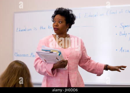 Ein afrikanischer amerikanischer Professor unterrichtet eine Klasse beim stehen auf einem Whiteboard an einer Universität. Stockfoto