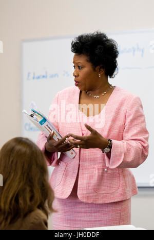 Ein afrikanischer amerikanischer Professor unterrichtet eine Klasse beim stehen auf einem Whiteboard an einer Universität. Stockfoto