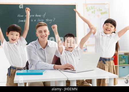 Männliche Lehrer Schüler im Klassenzimmer zu studieren Stockfoto