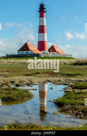 Ein Leuchtturm Reflexion eine Pfütze in der deutschen Nordsee Region, Deutschland, Nordfriesland Stockfoto