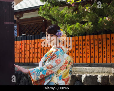 Junge japanische Frau posiert in Straße traditionellen Kimono trägt. Stockfoto