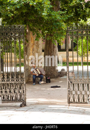 Straßenmusiker spielen Akkordeon vor den Toren zu den königlichen Gärten im königlichen Palast von Aranjuez in der Provinz Madrid in Spanien Stockfoto