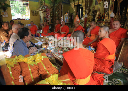 Sitzende buddhistische Mönche singen und gebeten an einer buddhistischen Zeremonie zu lesen. Wat Simuong. Wat Si Muang. Vientiane. Laos. Stockfoto