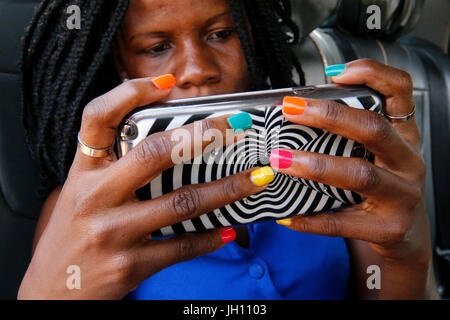 Ugandischen Frau mit lackierten Nägel mit einem Handy. Uganda. Stockfoto