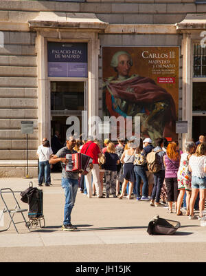 Mann Klavier Akkordeon zu spielen, Leute Schlange, um Zutritt zu den königlichen Palast zu unterhalten / Palacio Real in Madrid Spanien Stockfoto