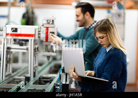 Zwei junge hübsche Ingenieure arbeiten an Elektronikkomponenten Stockfoto