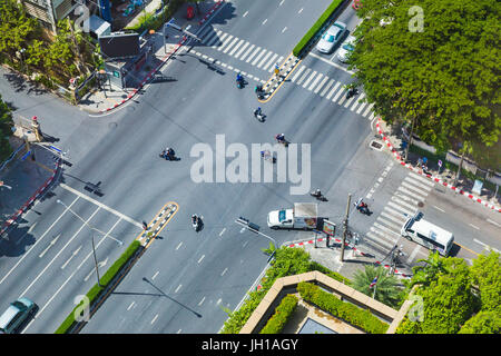 Bangkok, Thailand - 6. Juli 2017 - Blick auf eine Straßenkreuzung in Bangkok zeigt Autos und Motorrad gehen über ihr Geschäft an einem sonnigen Tag Stockfoto