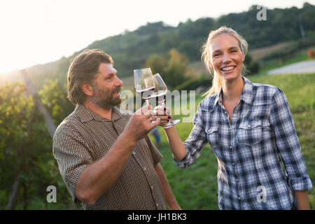 Weinbauern Toasten mit Rotwein im Weinberg Stockfoto