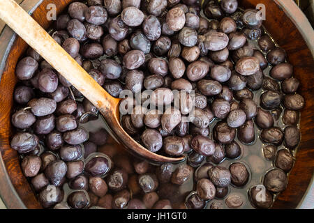 Oliven in Holzschalen mit Löffel servieren. Stockfoto