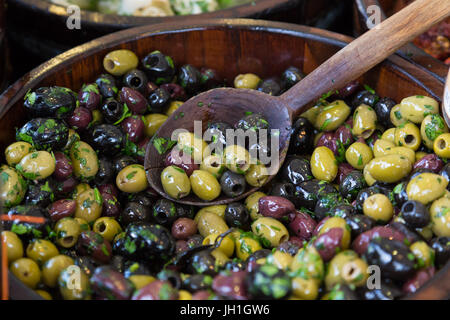 Oliven in Holzschalen mit Löffel servieren. Stockfoto