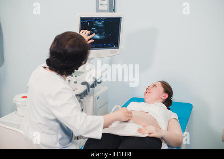 Schwangere Frau, die Ultraschallbehandlung im Krankenhaus Stockfoto