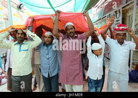 Ajmer Sharif Dargah, Rajasthan. Gläubigen tragen Chadars (Teppich-Angebote). Indien. Stockfoto