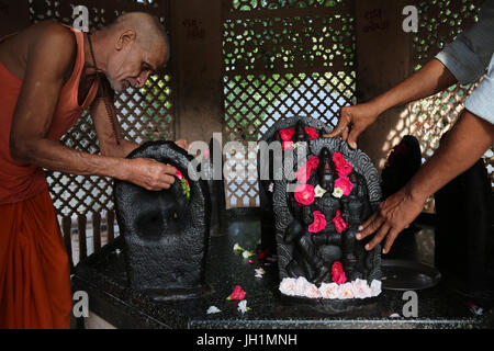 Hindu-Tempel Anhänger Blumen auf Murthis in Raman Reti platzieren. Indien. Stockfoto