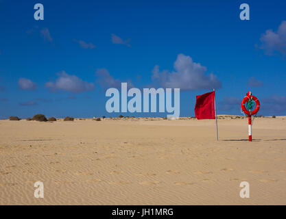 Schwimmen Kreis. Leben rote Farbe Boje am Strand mit hellem Sand und Himmel Hintergrund. Zwei Warnzeichen. Schutztür, Rettungsring, Rettungsschwimmer. Urlaub am Meer. Stockfoto