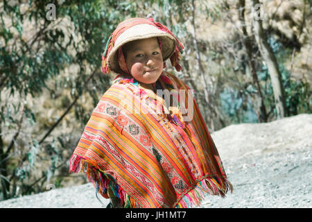 Lächelnde einheimische peruanische Junge bunte handgemachte traditionelle Poncho und einen Hut tragen. 21. Oktober 2012 - Patacancha, Cusco, Peru Stockfoto