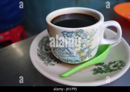 Dampfende traditionelle orientalische chinesische Kopitiam Stil dunkel Kaffee in Vintage Tasse und Untertasse Stockfoto