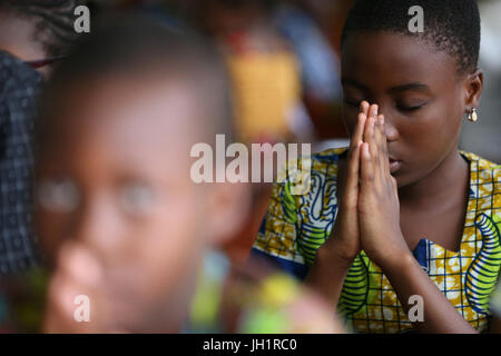 Sonntagmorgen katholische Messe.  Junges Mädchen beten.  Lome. Togo. Stockfoto