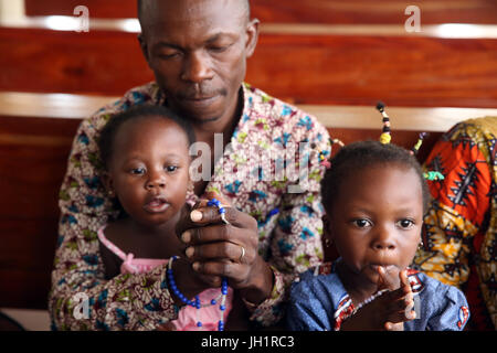 Sonntagmorgen katholische Messe.  Afrikanischer Mann mit Rosenkranz beten.  Lome. Togo. Stockfoto
