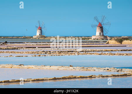 Salzpfannen und Windmühlen in der Lagune Stagnone zwischen Marsala und Trapani an der Westküste Siziliens, Italien. Stockfoto
