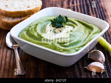 Cremige Broccolisuppe mit Rahmsauce, vegetarische Creme Suppe in eine Schüssel geben Stockfoto