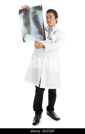 Volle Länge attraktive junge männliche südostasiatischen Arzt untersucht Röntgenaufnahme Scan stehen auf weißem Hintergrund isoliert. Stockfoto