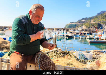 Fischer flickt Netze am Hafen von Cetara, malerische Fischerdorf, Amalfi-Küste, UNESCO-Weltkulturerbe, Campania, Italien Stockfoto