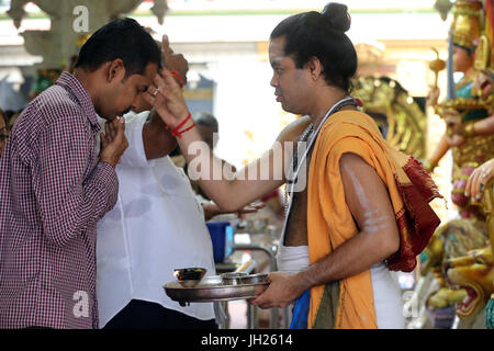 Sri Veeramakaliamman Hindu-Tempel.  Hinduistischen Brahmanen Priester.   Tika anwenden. Hindu Anhänger bei einem Morgengebet oder Puja.  Singapur. Stockfoto