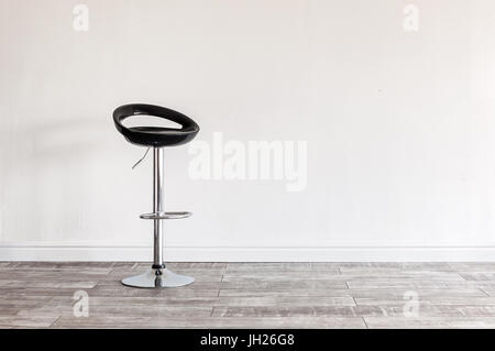 Moderne schwarze Barhocker vor Wand mit Exemplar. Stockfoto