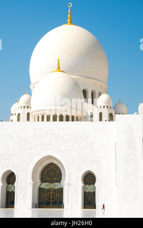 Innere des Scheich-Zayid-Moschee, Marmor Gebäude unterbrochen durch kleine Frau in rot, Abu Dhabi, Vereinigte Arabische Emirate Stockfoto