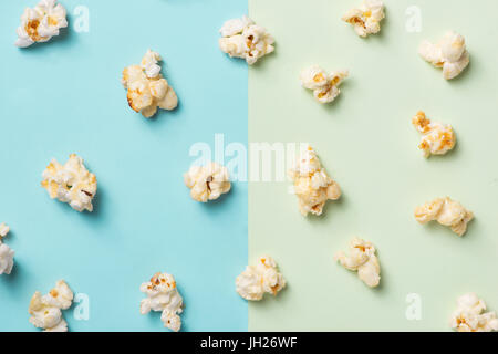 Das Popcorn in Pappbecher auf grünen und blauen Hintergrund. Stockfoto