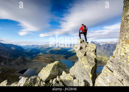 Wanderer auf Felsen bewundert die blaue See Montespluga im Sommer Tal Chiavenna, Veltlin, Lombardei, Italien, Europa Stockfoto