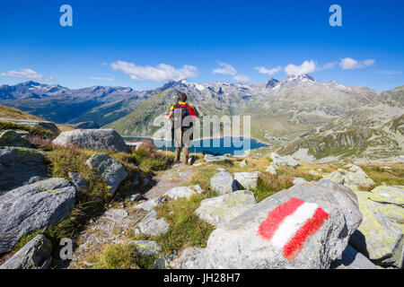 Wanderer bewundert die blaue See Montespluga und felsigen Gipfeln im Sommer Tal Chiavenna, Veltlin, Lombardei, Italien, Europa Stockfoto