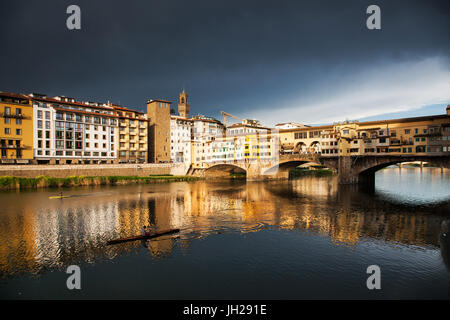 Ponte Vecchio spiegelt sich in den Fluss Arno gegen dunkle blaue Gewitterhimmel, Florenz, UNESCO-Weltkulturerbe, Toskana, Italien Stockfoto