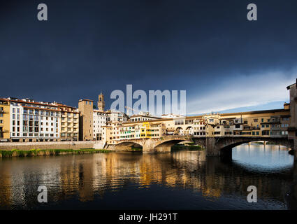 Ponte Vecchio reflektiert in den Arno rRver gegen dunkle blaue Gewitterhimmel, Florenz, UNESCO World Heritage Site, Toskana, Italien Stockfoto