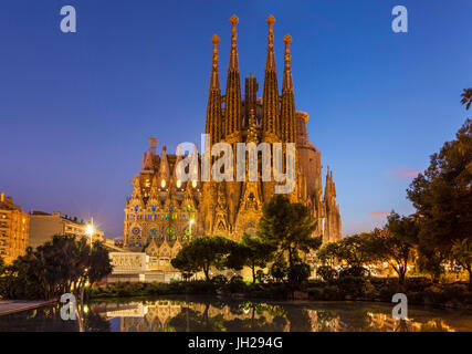 La Sagrada Familia Kirche beleuchtet in der Nacht, entworfen von Antoni Gaudi, UNESCO, spiegelt sich im Pool, Barcelona, Katalonien, Spanien Stockfoto