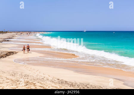 Touristen zu Fuß entlang des Sandstrandes, Ponta Preta beach, Santa Maria, Insel Sal, Kap Verde, Atlantik, Afrika Stockfoto