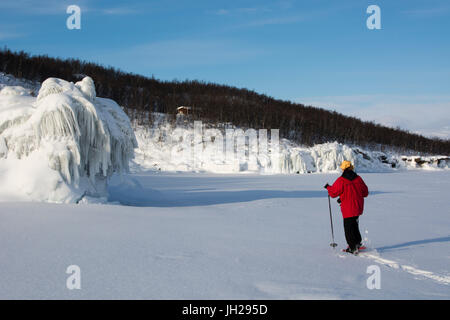 Eine Frau, die zu Fuß über den zugefrorenen See Tornetrask, Abisko Nationalpark, Schweden, Skandinavien, Europa Stockfoto