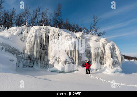 Eine Frau betrachtet man spektakuläre Eisformationen, Tornetrask See, Nationalpark Abisko, Schweden, Skandinavien, Europa Stockfoto