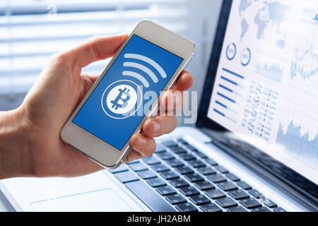 Person sendet Bitcoin mit Smartphone für Online-Zahlung, Nahaufnahme von Handy-Bildschirm, Business Office-Hintergrund Stockfoto