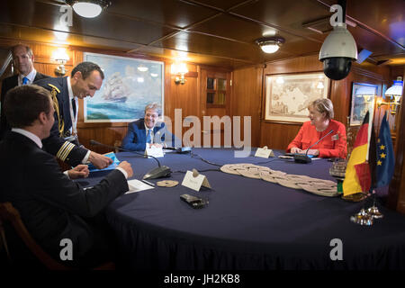 HANDOUT - Handout Bild datiert 12. Juli 2017 zeigt Bundeskanzlerin Angela Merkel (von rechts nach links), italienische Ministerpräsident Paolo Gentiloni und der französische Präsident Emmanuel Macron im Gespräch an Bord der Schule Schiff Goletta Palinuro vor der Westbalkan-Gipfel in Triest, Italien. Dieses Treffen fand im Vorfeld des Gipfels mit sechs West-Balkan-Staaten zusammen mit mehreren EU-Ländern in der nördlichen Stadt Triest. (ACHTUNG REDAKTION: REDAKTIONELLE NUTZUNG NUR IM ZUSAMMENHANG MIT DER AKTUELLEN BERICHTERSTATTUNG/OBLIGATORISCHEN CREDITS) Foto: Guido Bergmann/Bundesregierung/dpa Stockfoto