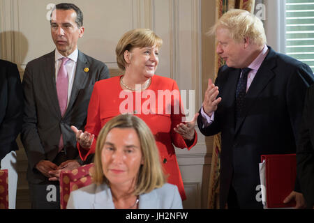 HANDOUT - Handout Bild datiert 12. Juli 2017 zeigt Bundeskanzlerin Angela Merkel und der britische Außenminister Boris Johnson im Gespräch am Rande der Westbalkan-Gipfel in Triest, Italien. Hohe Vertreterin der EUS für Außen- und Sicherheitspolitik, Federica Mogherini, können in den Vordergrund, gesehen werden, während der österreichische Bundeskanzler Christian Kern im Hintergrund steht. Die jährliche Serie von Konferenzen, die im Jahr 2014 zum Leben von Berlin und die Staats- und Regierungschefs der Länder des Balkans gebracht wurde, soll die Region für einen späteren Einstieg in den E vorbereiten Stockfoto